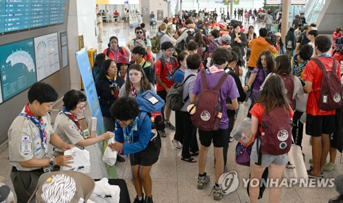 12일 오전 인천국제공항에서 세계스카우트 잼버리 대원들이 출국 전 선물을 받고 있다. [공항사진기자단=연합뉴스]