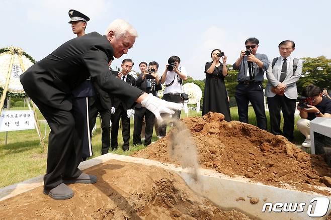 제78주년 8·15 광복절을 하루 앞둔 14일 오전 서울 동작구 국립서울현충원 애국지사 묘역에서 열린 독립운동가 최재형 선생과 배우자 최 엘레나 페트로브나 여사의 합동 안장식에서 최 선생의 손자 최파벨 씨가 허토하고 있다. 2023.8.14/뉴스1 ⓒ News1 민경석 기자