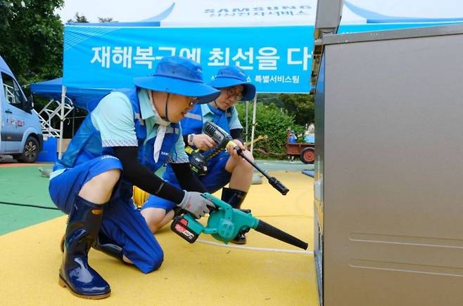 삼성전자서비스가 14일 강원도 고성군 거진청소년문화의집에 이동식 서비스센터를 설치하고 침수된 가전제품 세척, 점검, 수리 등 '수해 복구 특별서비스'를 하는 모습.[사진제공=삼성전자서비스]