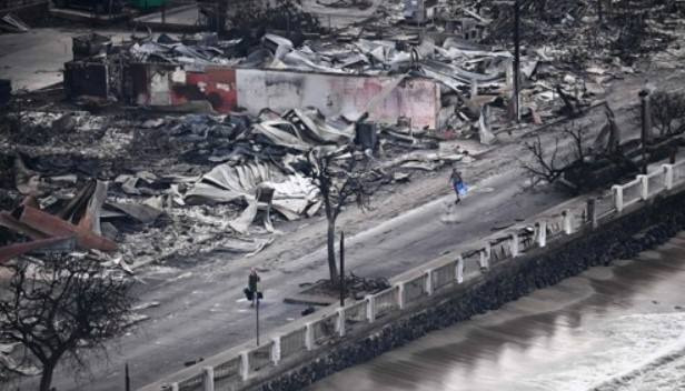 10일(현지시간) 산불로 까맣게 타버린 미국 하와이 마우이섬 라하이나에서 주민들이 걷고 있다. AFP. 연합뉴스