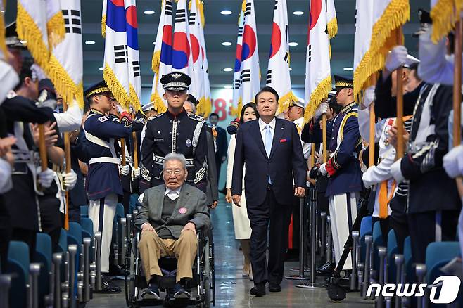 윤석열 대통령이 15일 서울 서대문구 이화여대 대강당에서 열린 제78주년 광복절 경축식에서 오성규 애국지사와 함께 입장하고 있다. (대통령실 제공) 2023.8.15/뉴스1 ⓒ News1 오대일 기자