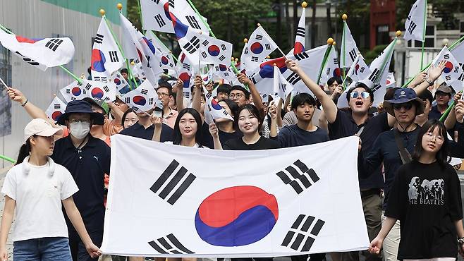 '태극기 물결 대행진' 행사에 참가한 시민들이 태극기를 흔들며 종로구청에서 보신각으로 걸어가고 있다. 연합뉴스