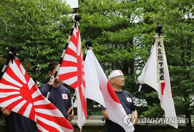 야스쿠니신사서 욱일기와 일장기 든 사람들 (도쿄=연합뉴스) 박상현 특파원 = 일본 패전일인 15일 태평양전쟁 A급 전범이 합사된 도쿄 지요다구 야스쿠니신사에서 남색 제복을 입은 사람들이 욱일기와 일장기를 들고 있다. "천황 폐하 만세"라는 글자도 보인다. 2023.8.15