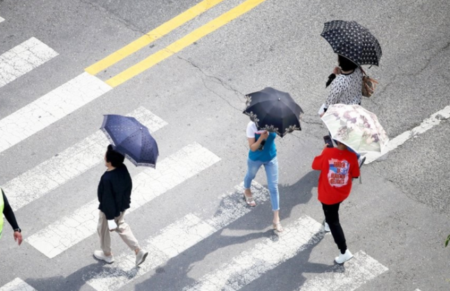 광주 서구 치평동에서 시민들이 햇빛을 가리려 양산을 쓰고 걷고 있다.ⓒ연합뉴스