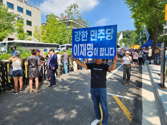 이재명 더불어민주당 대표가 네 번째 검찰 소환 조사에 응한 17일 오전, 서울 서초동 법원삼거리 앞에서 이 대표 지지자들이 응원전을 펴고 있다. '강한 민주당 이재명이 합니다'라는 팻말을 든 지지자 뒤로 경찰이 쳐둔 철제 울타리 안이 휑하다. 정용환 기자.