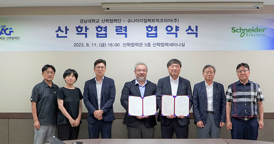 Suh Sang-hoon, business vice president of industrial automation at Schneider Electric Korea, fourth from left, and Kang Jae-kwan, vice president for industry-academic cooperation foundation at Kyungnam University, pose for a photo with related officials on Aug. 11 after signing a partnership to jointly nurture future engineers specializing in industrial automation at the university in Changwon, South Gyeongsang. [KYUNGNAM UNIVERSITY]