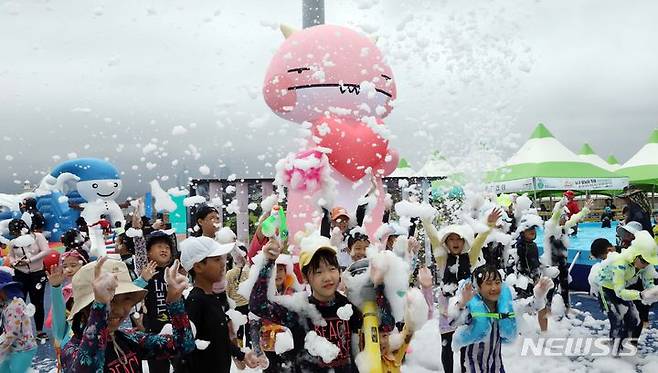 [부산=뉴시스] 하경민 기자 = 부산지역에 엿새째 폭염주의보 발효 중인 16일 남구 용호별빛공원에서 열린 '2023년 남구 물놀이 축제'를 찾은 어린이들이 인체에 무해한 거품 눈을 맞고 있다. 오는 20일까지 운영되는 물놀이축제에는 수영장 4개와 워터슬라이드, 페달보트, 챌린저바운스 등 물놀이 시설을 비롯해 물총싸움과 마술공연, 댄스공연 등 부대행사도 마련된다. 2023.08.16. yulnetphoto@newsis.com