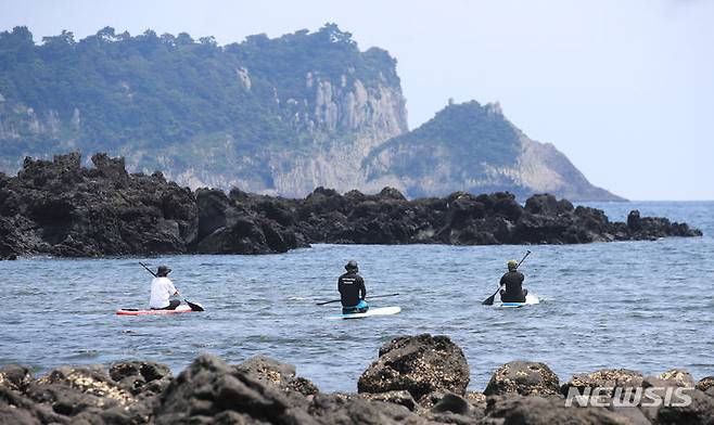 [서귀포=뉴시스] 우장호 기자 = 지난 16일 오후 제주 서귀포시 서건도 앞바다에서 멀리 범섬을 배경으로 '텐타임즈' 수강생들이 패드보드를 즐기고 있다. 2023.08.17. woo1223@newsis.com