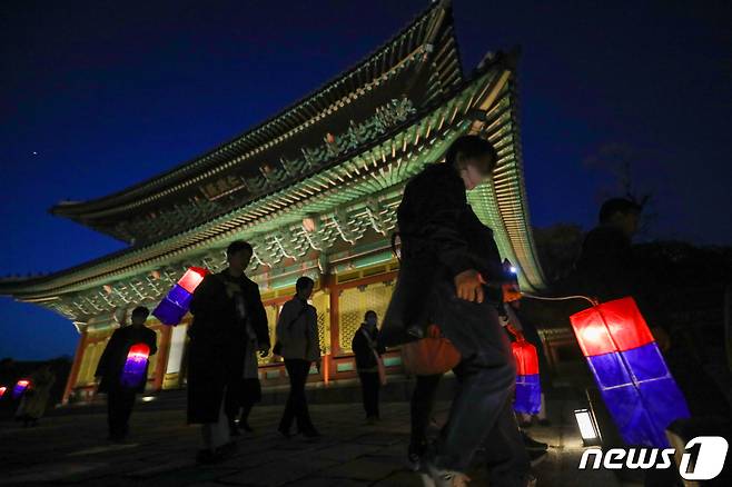 12일 오후 서울 종로구 창덕궁에서 열린 '2023 창덕궁 달빛기행'을 찾은 관람객들이 청사초롱을 들고 궁궐을 둘러보고 있다. 2023.4.12/뉴스1 ⓒ News1 민경석 기자