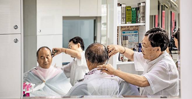 서울 마포구 공덕동 '성우이용원'의 이남열 이발사가 40년 단골 손님의 머리를 깎고 있다. 이 이발사는 "가위 날을 제대로 갈면 머리카락이 사방으로 튀지 않고 밑으로 뚝뚝 떨어진다"며 "연장을 완벽하게 관리하는 것이 이발사의 기본 자세"라고 했다. /장은주 영상미디어 객원기자
