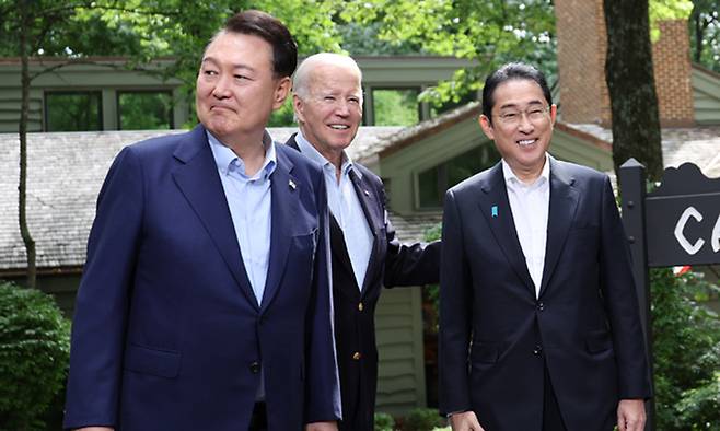 윤석열 대통령과 조 바이든 미국 대통령, 기시다 후미오 일본 총리가 18일(현지시간) 워싱턴DC 인근 미국 대통령 별장인 캠프 데이비드에서 열린 한미일 정상회의를 앞두고 로렐 로지 앞에서 기념 촬영을 하고 있다. 연합뉴스