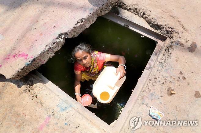 인도 서북부 구자라트주 아메다바드시 길거리 수도관에서 식수를 받아 플라스틱 통에 넣는 여성 [EPA 연합뉴스 자료사진. 재판매 및 DB 금지]