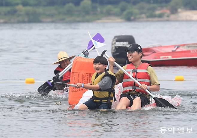 20일 서울 송파구 잠실한강공원에서 재활용 소재를 활용해 나만의 ‘배’를 만들어 한강을 돌아오는 ‘나만의 한강호 경주대회’가 열렸다. 참가자들이 힘차게 노를 젓고 있다. 2023 한강 페스티벌 여름 프로그램의 하나로 진행됐다. 김재명 기자 base@donga.com