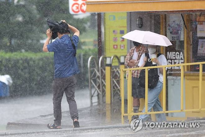 소나기가 내리자 시민들이 비를 피하기 위해 뛰어가고 있다. [연합뉴스 자료사진]
