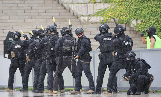 Members of the police's Special Operation Unit in tactical gear respond to a mock terrorist attack at the National Assembly in Yeouido, western Seoul, on Monday. The Ulchi Exercise, scheduled to continue until Sunday, involves not only police and emergency personnel but also Korea’s civil authorities. [YONHAP]