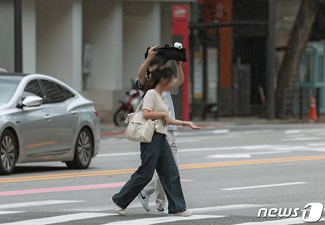 소나기가 내리는 21일 오후 서울 종로구 종각역 사거리에서 우산을 준비하지 못한 시민들이 발걸음을 재촉하고 있다. 2023.8.21/뉴스1 ⓒ News1 이재명 기자