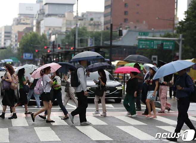 22일 서울 종각역 버스정류장에서 시민들이 우산을 쓴 채 출근하고 있다. 기상청은 이날 서쪽 지방을 시작으로 중부와 호남 지방에 비가 내리다가 내일은 전국으로 확대될 것으로 예보했다. 2023.8.22/뉴스1 ⓒ News1 신웅수 기자