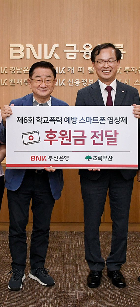 BNK부산은행 강석래 경영기획본부장(오른쪽)과 초록우산어린이재단 이홍렬 홍보대사가 후원금 전달 후 기념촬영을 하고 있다. BNK부산은행 제공