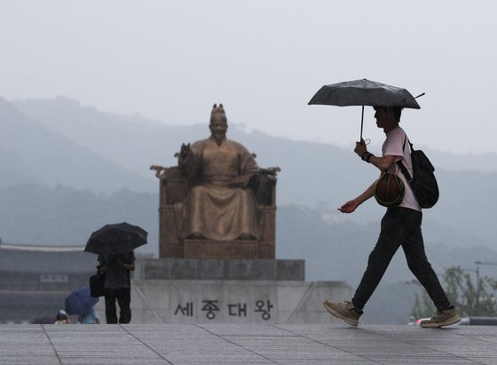 22일 서울 광화문 광장에서 시민이 우산을 쓰고 걸어가고 있다. 기상청은 이날 서쪽 지방을 시작으로 중부와 호남 지방에 비가 내리다가 전국으로 확대될 것으로 예보했다. 뉴스1