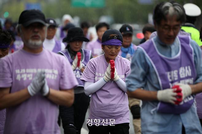 이태원 유가족들이 빗속에서 삼보일배를 하고 있다.