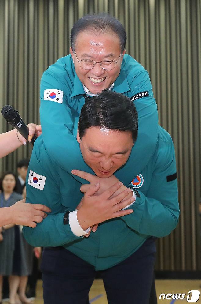 공습 대비 민방위 훈련(민방공훈련)이 실시된 23일 서울 여의도 국회 지하강당에서 정희용 국민의힘 의원이 윤재옥 원내대표를 업고 부상자 이송법 훈련을 하고 있다. 2023.8.23/뉴스1 ⓒ News1 임세영 기자