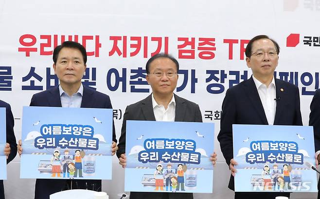 [서울=뉴시스] 전진환 기자 = 윤재옥 국민의힘 원내대표와 참석자들이 27일 오후 서울 여의도 국회에서 열린 우리바다 지키기 검증 TF 주최 '수산물 소비 및 어촌휴가 장려' 캠페인에서 '여름보양은 우리 수산물로'라고 적힌 피켓을 들고 있다.  2023.07.27. amin2@newsis.com