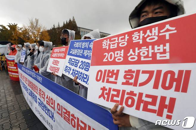 전국교직원노동조합(전교조) 관계자들이 8일 오전 서울 영등포구 여의도 국회의사당 앞에서 '학급당 학생 수 20명 상한법 즉각 의결 촉구 기자회견'을 하고 있다. 전교조는 이날 "학급당 20명은 자라나는 세대에게 학교 교육을 제대로 보장하기 위한 국민들의 절박한 요구다＂라면서 ＂코로나19로 심화된 교육 불평등을 양질의 공교육으로 회복하기 위해서는 과밀학급 해소가 더욱 시급하다＂고 주장했다. 2021.11.8/뉴스1 ⓒ News1 민경석 기자