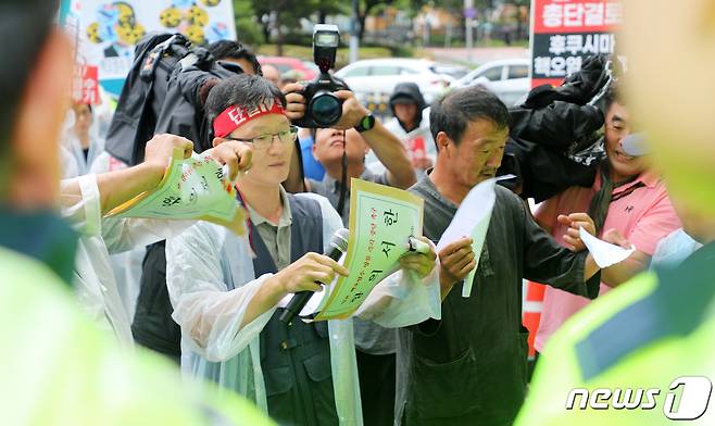 일본 정부가 후쿠시마 원전 오염수를 해양에 방류하기로 한 24일 제주시 노형동 주제주일본국총영사관 앞에서 제주 18개 진보정당과 시민단체로 구성된 '윤석열 정권 퇴진·한국사회 대전환 제주행동' 관계자들이 경찰에 막혀 미처 전달하지 못한 항의서한을 찢고 있다.2023.8.24./뉴스1 ⓒ News1 오미란 기자