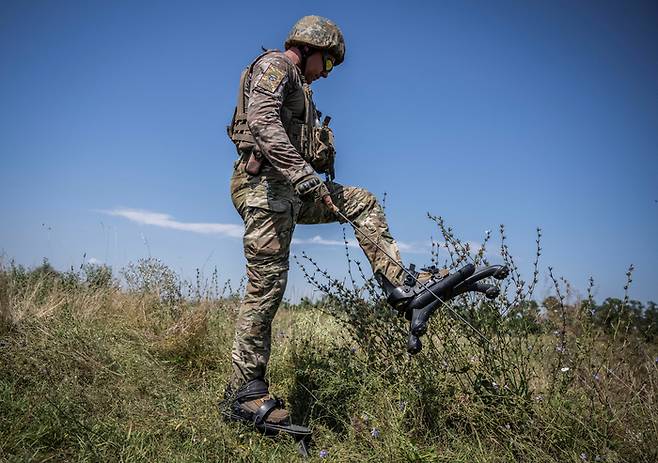 한 우크라이나군 병사가 ‘스파이더 부츠’를 신은 채 보행 중이다. 스파이더 부츠는 지면에서 병사의 발을 10여㎝ 띄우도록 고안돼 지뢰의 폭발력을 분산시킨다.  로이터연합뉴스