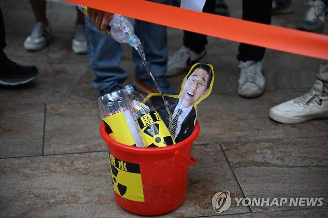 홍콩서 후쿠시마 오염수 방류 반대 시위 (홍콩 AFP=연합뉴스) 일본의 후쿠시마 원전 오염수 방류 계획에 반대하는 홍콩 어민이 22일 홍콩 일본 영사관 앞에서 기시다 후미오 총리의 사진에 물을 붓고 있다. 기시다 총리는 이날 관계 각료회의를 열어 오염수 방류 개시 일정을 24일로 결정했다. 2023.08.23 danh2023@yna.co.kr