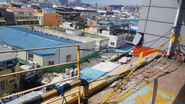 27일 자동차 추락사고가 일어난 경북 포항시 죽도시장 공영주차장. 차량과의 충돌로 인해 추락방지용 시설물인 철제 난간과 철제 볼라드(쇠파이프), 시설물이 박혀 있던 콘크리트 바닥까지 뜯겨 있다. 포항=김정혜 기자