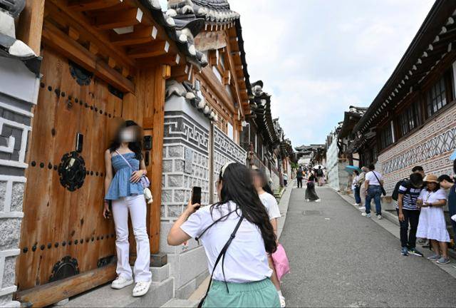 지난 21일 서울 종로구 북촌 한옥마을에서 외국인 관광객이 주택 대문 앞에 기대어 기념 촬영을 하고 있다. 왕태석 선임기자