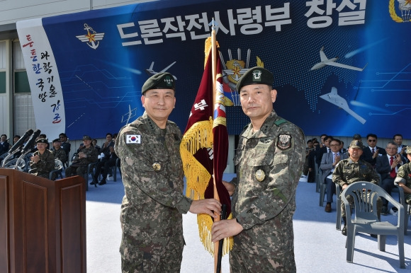 이보형 소장에게 부대기 수여하는 김승겸 합참의장 - 경기 포천시 옛 6군단 인근 15항공단 군 비행장에서 열린 드론작전사령부 창설식에서 김승겸 (왼쪽) 합참의장이 초대 드론작전사령관 이보형 소장에게 부대기를 수여하고 있다. 합참 제공