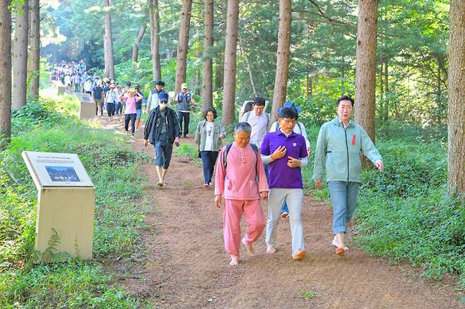 제1회 원주맨발걷기 축제가 2일 원주시 행구동 운곡솔바람숲길 일원에서 열린 가운데 원강수 원주시장(사진 오른쪽)이 참가자들과 맨발로 걷고 있다. 원주시 제공