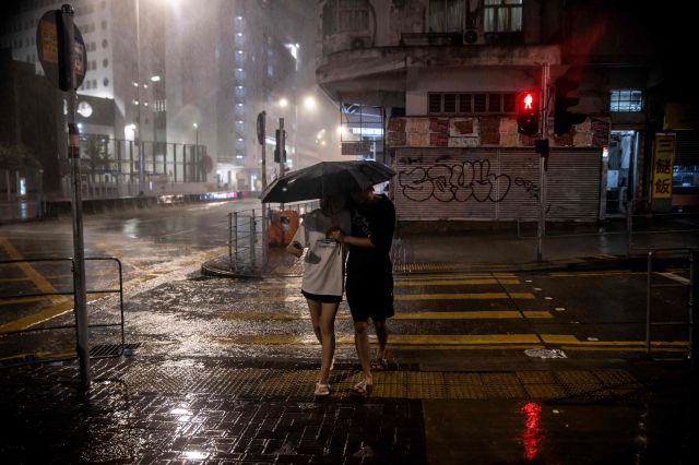 홍콩 시민들이 지난 1일 밤 제9호 태풍 ‘사올라’의 강우 속에서 이동하고 있다. AFP연합뉴스
