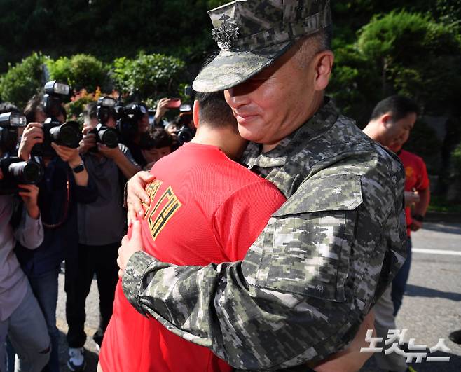 채 모 상병 순직 사건을 수사하다 항명 혐의로 입건된 박정훈 전 해병대 수사단장(대령)이 1일 오전 영장실질심사를 받기 위해 서울 용산구 군사법원으로 들어가기 전 응원에 나선 해병대 예비역 동기생들과 포옹하고 있다. 류영주 기자