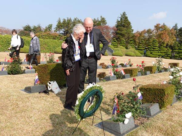 리아 라드스타트(오른쪽에서 두 번째) 씨가 지난해 11월 아들과 함께 부산 남구 유엔기념공원을 방문해 오빠인 헨드릭 묘지 앞에서 오열하고 있다.  재한유엔기념공원관리처 제공