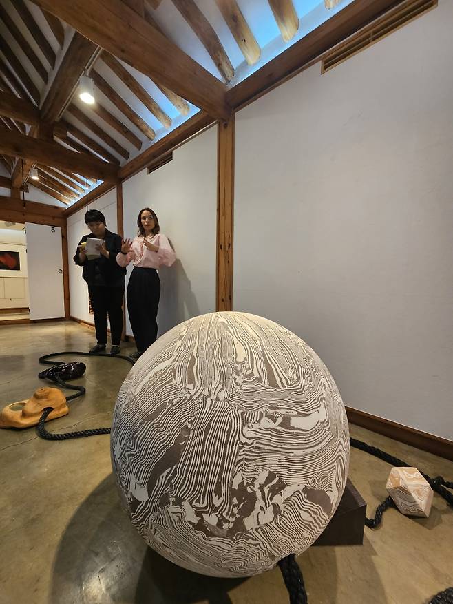 Louise Hayward, partner of Lisson Gallery (right), gives a tour to the press at the pop-up exhibition, "Time Curve," Thursday. (Park Yuna/The Korea Herald)