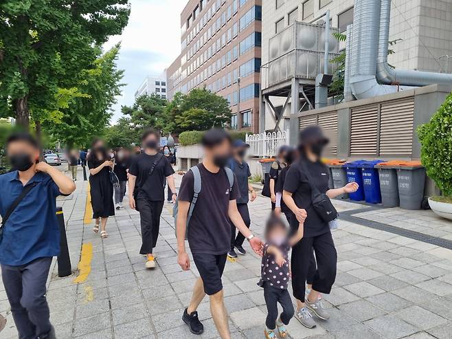 4일 오후 6시께 서울 영등포구 국회 앞에서 열린 서이초 교사 49재 추모 집회에 참가한 한 교사가 자녀와 함께 이동하고 있다. 김영철 기자