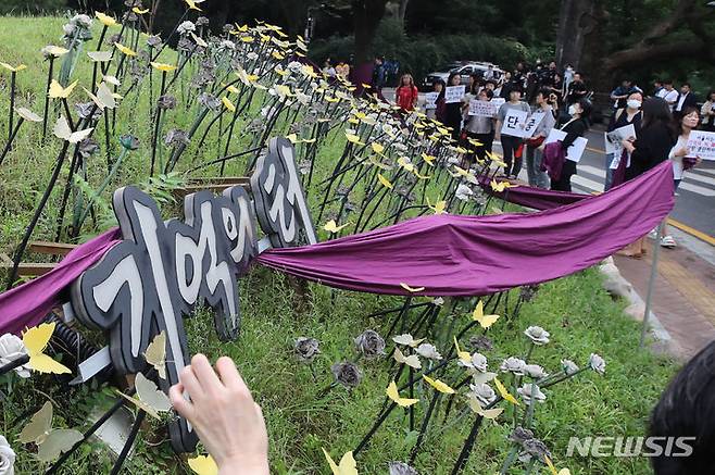 [서울=뉴시스] 권창회 기자 = 4일 오전 서울 중구 남산 기억의 터에서 정의기억연대를 비롯한 여성단체 회원들이 서울시 기억의 터 기습철거 규탄 행동의 일환으로 보라색 띠를 두르고 있다. 2023.09.04. kch0523@newsis.com