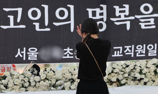 3일 서울 양천구의 한 초등학교 정문에 마련된 교사 A씨 추모공간을 방문한 시민이 눈물을 흘리고 있다. 연합뉴스