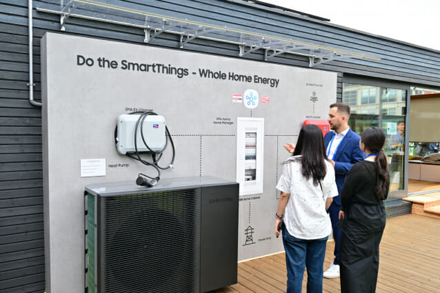 삼성전자 직원이 넷 제로 홈(Net Zero Home)' 솔루션으로 꾸며진 타이니 하우스 외관에 소개된 SMA와 ABB의 에너지 생산/저장 시스템을 소개하고 있다.(사진=삼성전자)