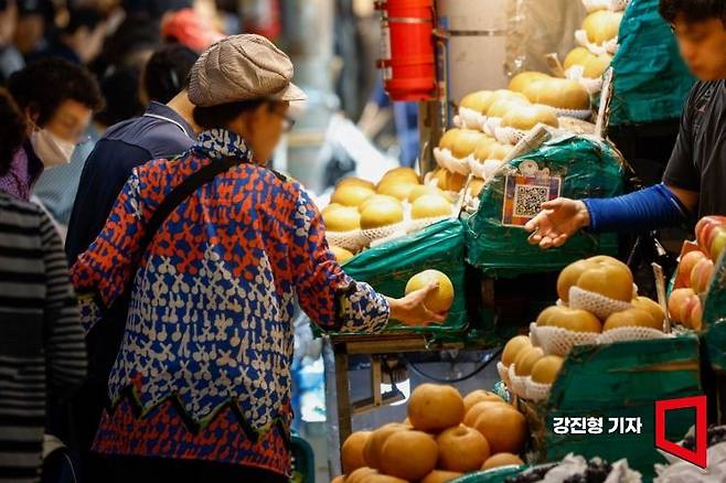 장마와 태풍으로 사과를 비롯한 과일과 채소값이 크게 오른 가운데 28일 서울 동대문구 경동시장을 찾은 시민들이 과일을 구매하고 있다. 사진=강진형 기자aymsdream@