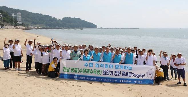 지난 4일 전남 장흥 수문해수욕장 일대에서 Sh수협은행과 수협중앙회가 공동으로 진행한 '해안가 환경정화 플로깅' 캠페인에 앞서 참가자들이 함께 기념촬영을 하고 있다. Sh수협은행 제공