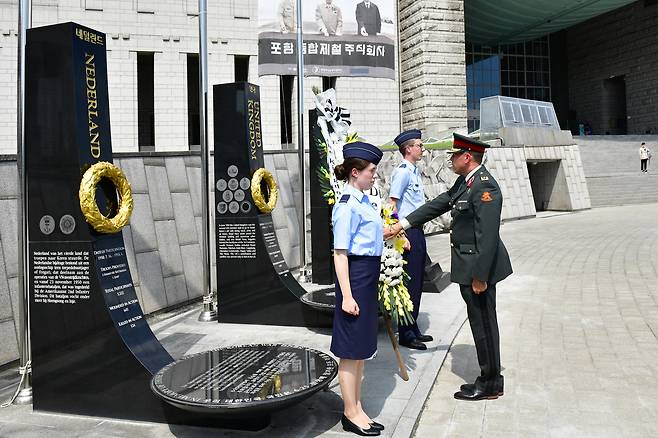 마르코 스네이크 네덜란드 국방부 재정관리국장이 전쟁기념관 평화의광장 네덜란드 참전기념비에서 네덜란드 국방부 초급 장교단과 헌화하고 있다.(전쟁기념사업회 제공)