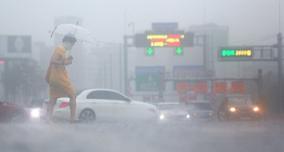 본격적인 장마가 시작된 7월 13일 비가 쏟아지는 서울 여의대로 횡단보도 위로 우산을 쓴 시민들이 지나고 있다. 연합뉴스