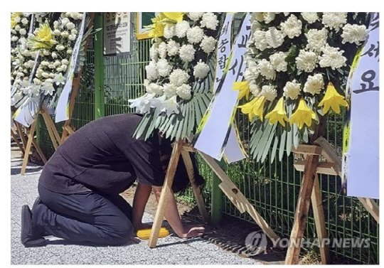 8일 오후 숨진 교사가 근무했던 대전 유성구의 초등학교 앞에서 한 동료 교사가 근조화환 앞에서 오열하고 있다. 연합뉴스