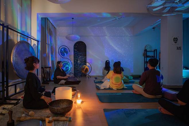 지난달 29일 서울 성북구에 있는 웰니스센터 ‘숲의 그림자’에서 열린 ‘공 사운드 배스’. 수련자들이 ‘핸드팬’ 소리에 집중하고 있다. 스튜디오 어댑터 염서정