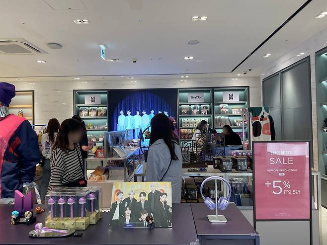 8일 오후 서울 중구 충무로 신세계면세점 명동점 BTS숍에서 쇼핑 중인 외국인 관광객. 매장 입구에는 중국어로 적힌 할인 안내판이 설치돼 있다. 전새날 기자