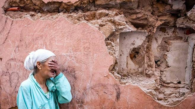 9일(현지시간) 모로코 마라케시의 구시가지에서 한 여성이 지진으로 파손된 집 앞에 서서 울고 있다. 연합뉴스